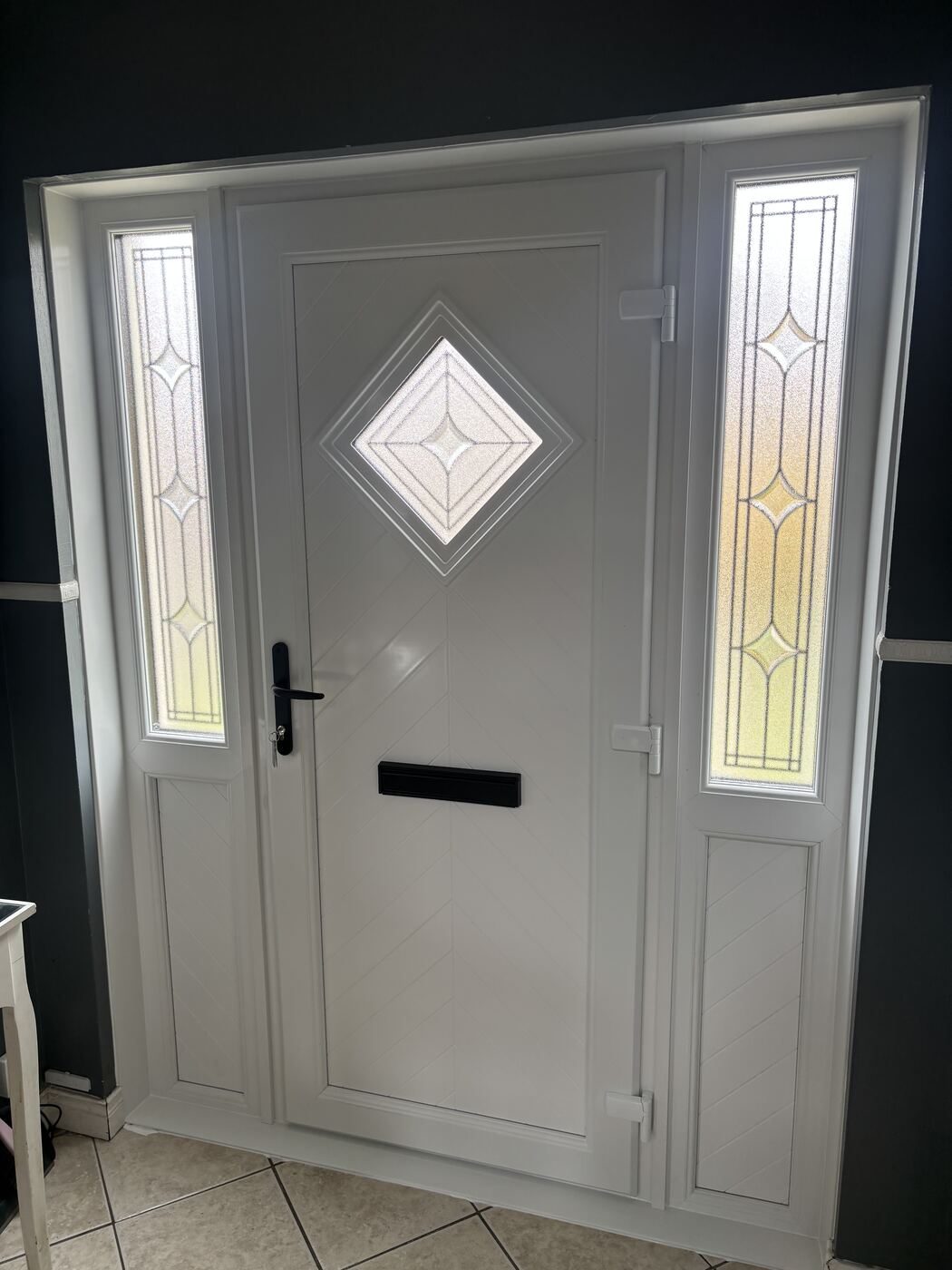 White uPVC door with diamond glass panel and decorative sidelights